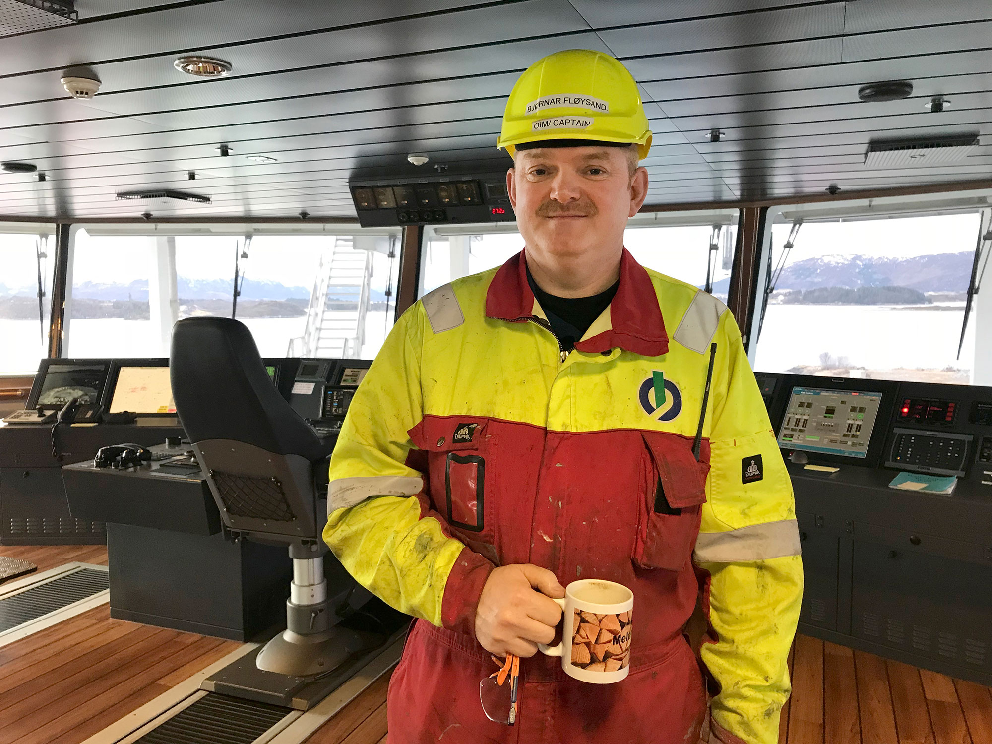 The captain on the bridge, the only interior area in which work overalls are accepted.